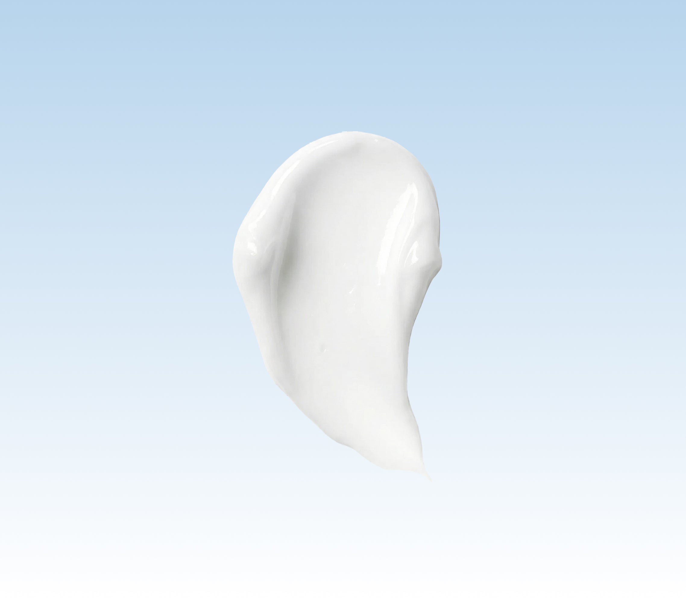 White cream or lotion smear on a light blue background